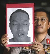 Maj. Gen. Nanan Sukarna showing portrait of Air Setiawan, a suspected militant killed in police raid, during press conference at main police hospital in Jakarta, 12 Aug 2009 