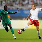 Tom De Mul of Belgium (R) strikes the ball as Nigeria's Sani Kaita looks on.