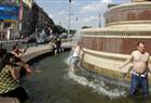 Tourists cool down themselves in a fountain at the central Prague's Wenceslas Square as the heat wave raised temperature over 35 degrees celsius on July 16, 2010