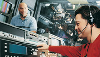 Man with a colleague working on a control panel in a TV studio