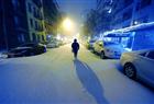 A New Yorker walks over a snow covered street on the Upper East Side on New York December 26, 2010 as a major snow storms hits the Northeast possibly dumping up to 18 inches of snow in the city.