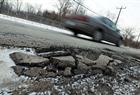 Cars stream past a pothole on the streets of Windsor on Wednesday, January 19, 2011.