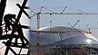 Silhouetten von Bauarbeitern neben Stadionbaustelle in Sotschi. | Bild: Fotos: dpa; Montage: BR